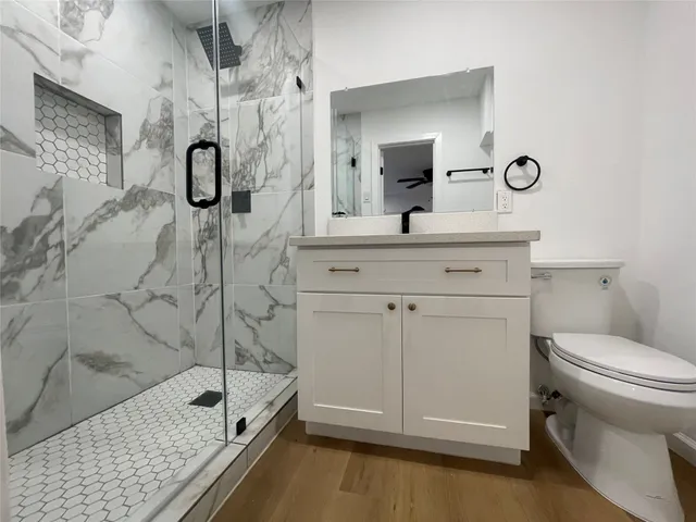 a bathroom with a sink a toilet and shower