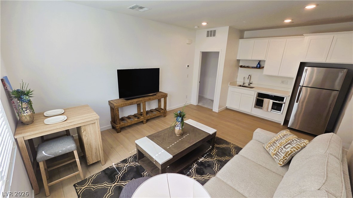 509 Arthur Pointe Street Henderson, NV 89011 - Photo 5 of 12 A compact living area combines relaxation and culinary spaces with bright, light-toned flooring.