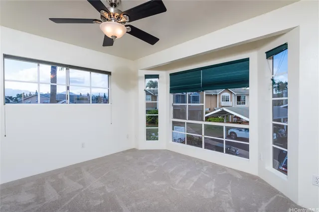 a view of an empty room with a ceiling fan and a window