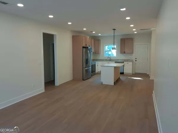 a view of a big room with wooden floor and windows