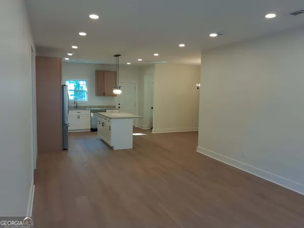 a large kitchen with a sink and dishwasher a refrigerator with wooden floor