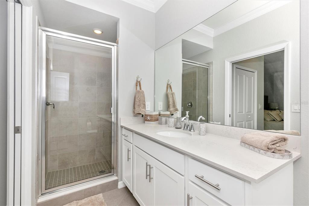 12280 Wellen Golf Street, Unit 403 Venice, FL 34293 - Photo 31 of 97 a bathroom with a shower sink vanity and mirror