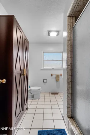 a spacious bathroom with a toilet a sink and mirror
