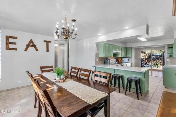 a dining room with furniture a chandelier and window