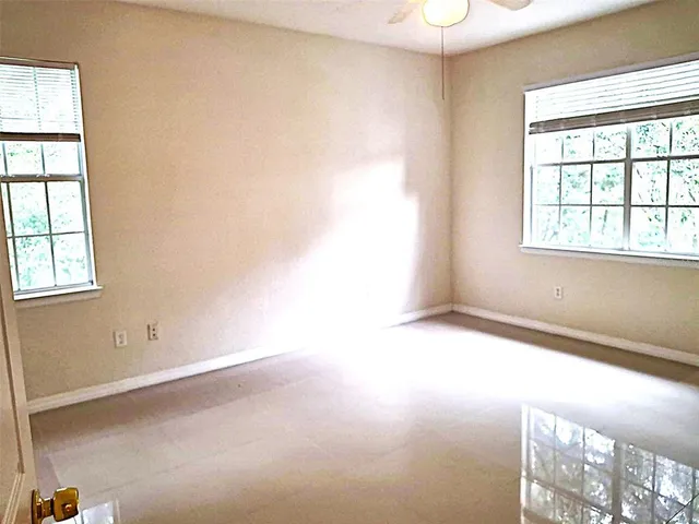 an empty room with windows and closet