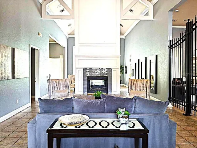 a view of a livingroom with furniture wooden floor fireplace and a chandelier