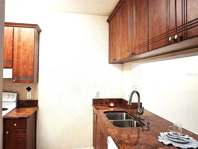 a kitchen with a sink a stove and cabinets