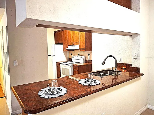 a kitchen with a sink and a stove with a dining table
