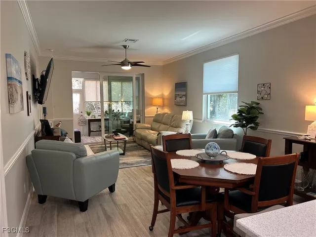 a living room with furniture a flat screen tv and a large window