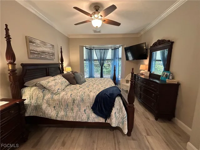 a bedroom with a bed a mirror and a large window