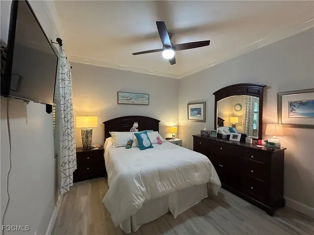 a bedroom with a bed and a large mirror on the dresser