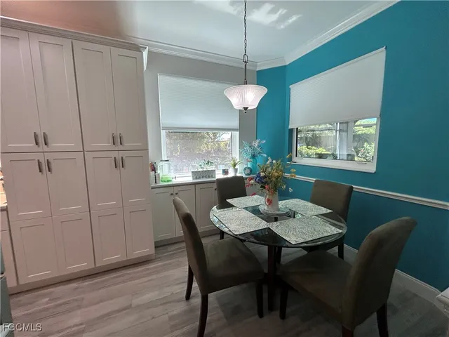 a dining room with wooden floor a chandelier a wooden table and chairs