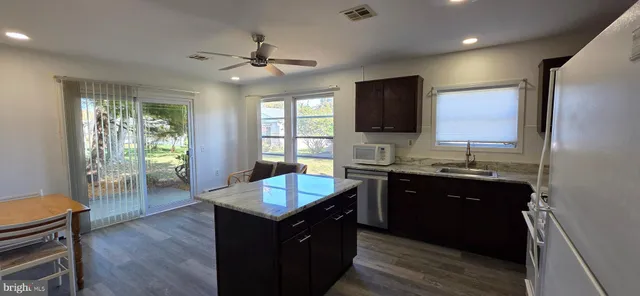 a kitchen with granite countertop a sink counter top space and appliances