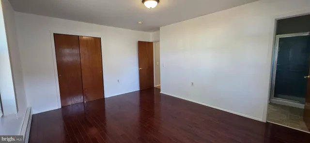 an empty room with wooden floor and closet