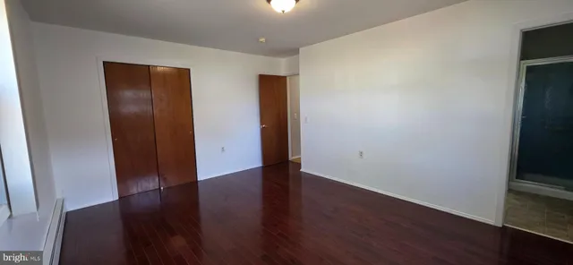 an empty room with wooden floor and closet