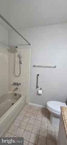 a bathroom with a granite countertop toilet a sink and bathtub