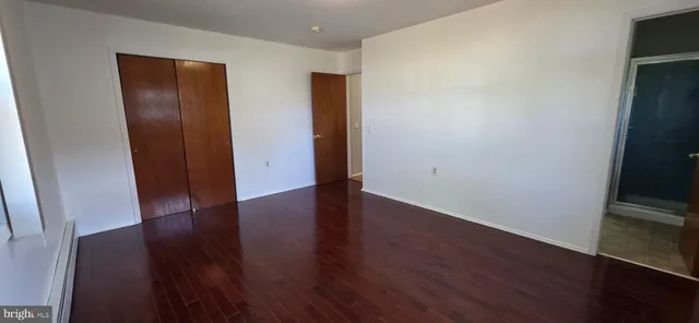 an empty room with wooden floor and closet