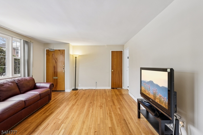 445 Morris Avenue, Unit D11 Springfield, NJ 07081 - Photo 3 of 16 a living room with a couch and a flat screen tv