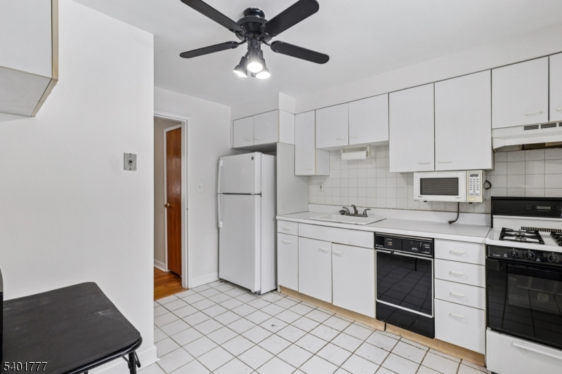 445 Morris Avenue, Unit D11 Springfield, NJ 07081 - Photo 5 of 16 a kitchen with stainless steel appliances a stove refrigerator sink and cabinets