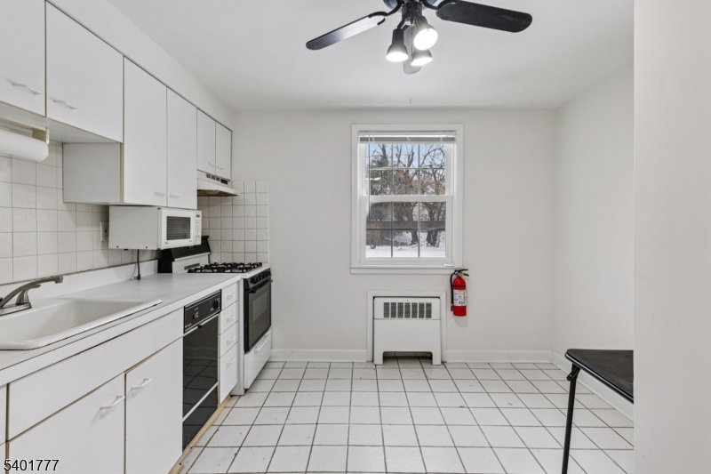 445 Morris Avenue, Unit D11 Springfield, NJ 07081 - Photo 6 of 16 a kitchen with a stove cabinets and window