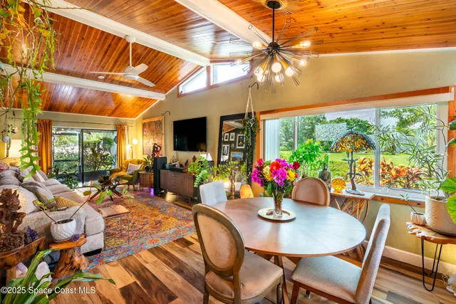 a view of a dining room with furniture a chandelier and wooden floor