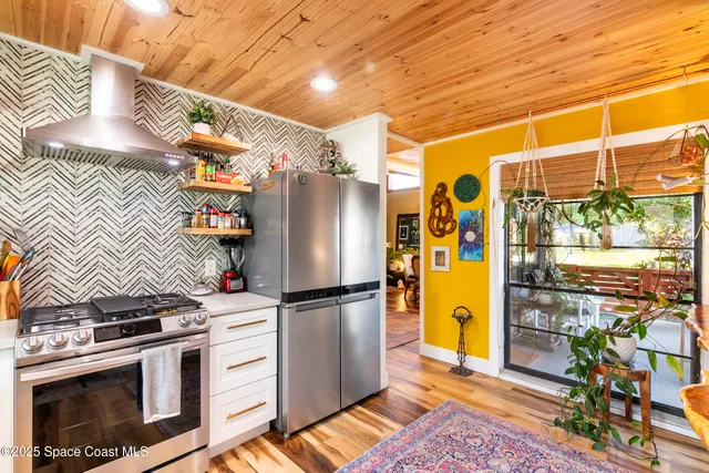 a kitchen with stainless steel appliances a stove a refrigerator and a wooden cabinets