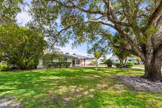 a view of a house with a yard and potted plants