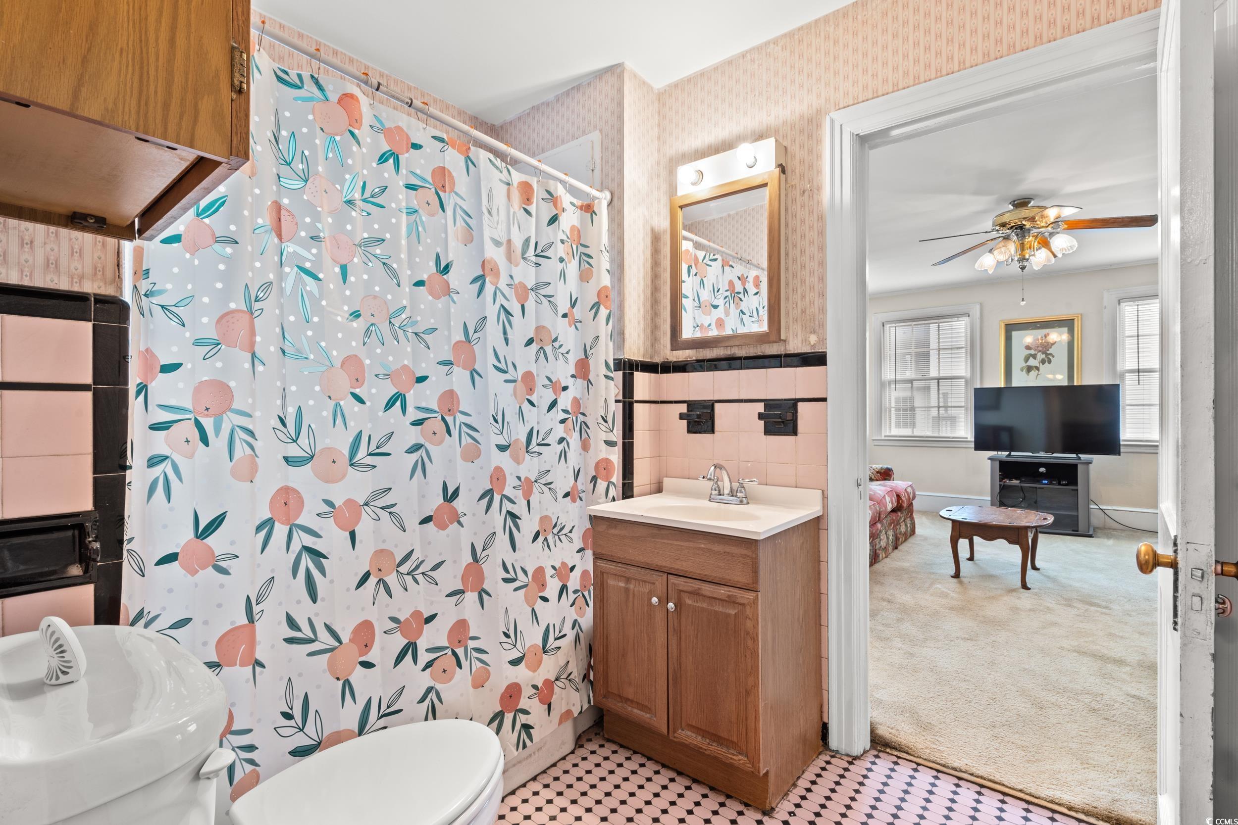 310 North Main Street Mullins, SC 29574 - Photo 23 of 35 Full bathroom with tile walls, curtained shower, vanity, light colored carpet, and wallpapered walls