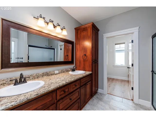 a bathroom with a granite countertop sink double vanity and mirror
