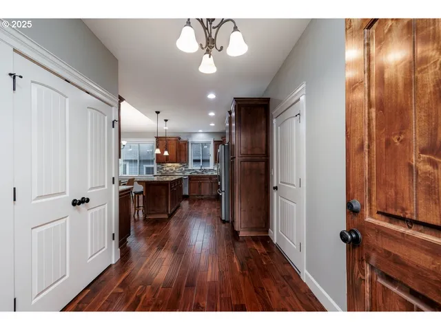 a open kitchen with kitchen island wooden floors appliances and cabinets