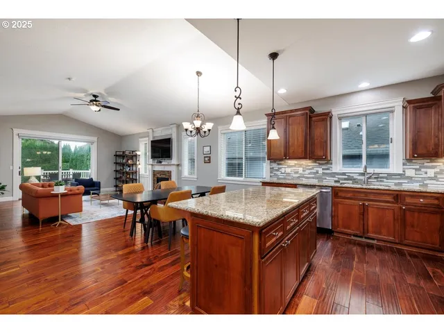a kitchen with stainless steel appliances granite countertop wooden floors and view living room