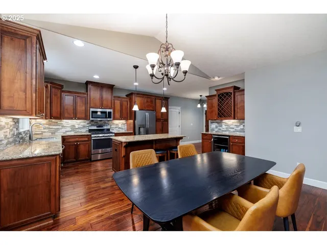 a view of kitchen with dining table wooden floor and kitchen view