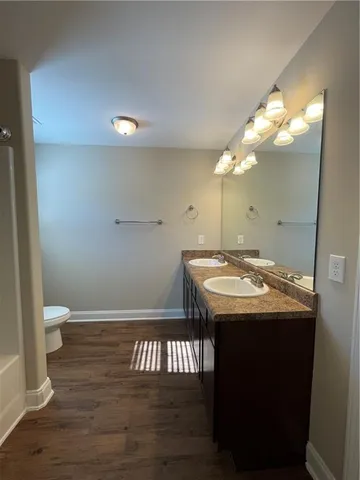a bathroom with a bathtub a sink and wooden floor