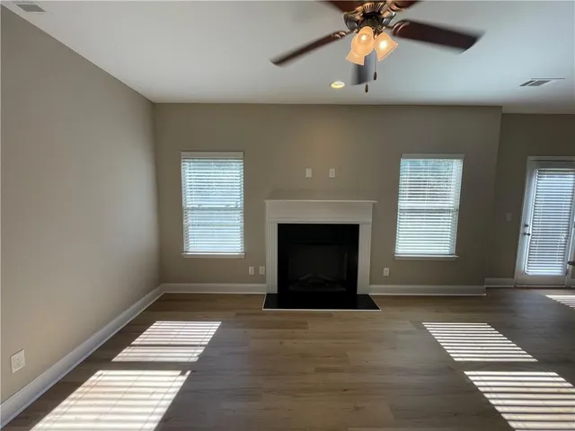 a view of a kitchen and a stove wooden floor a ceiling fan