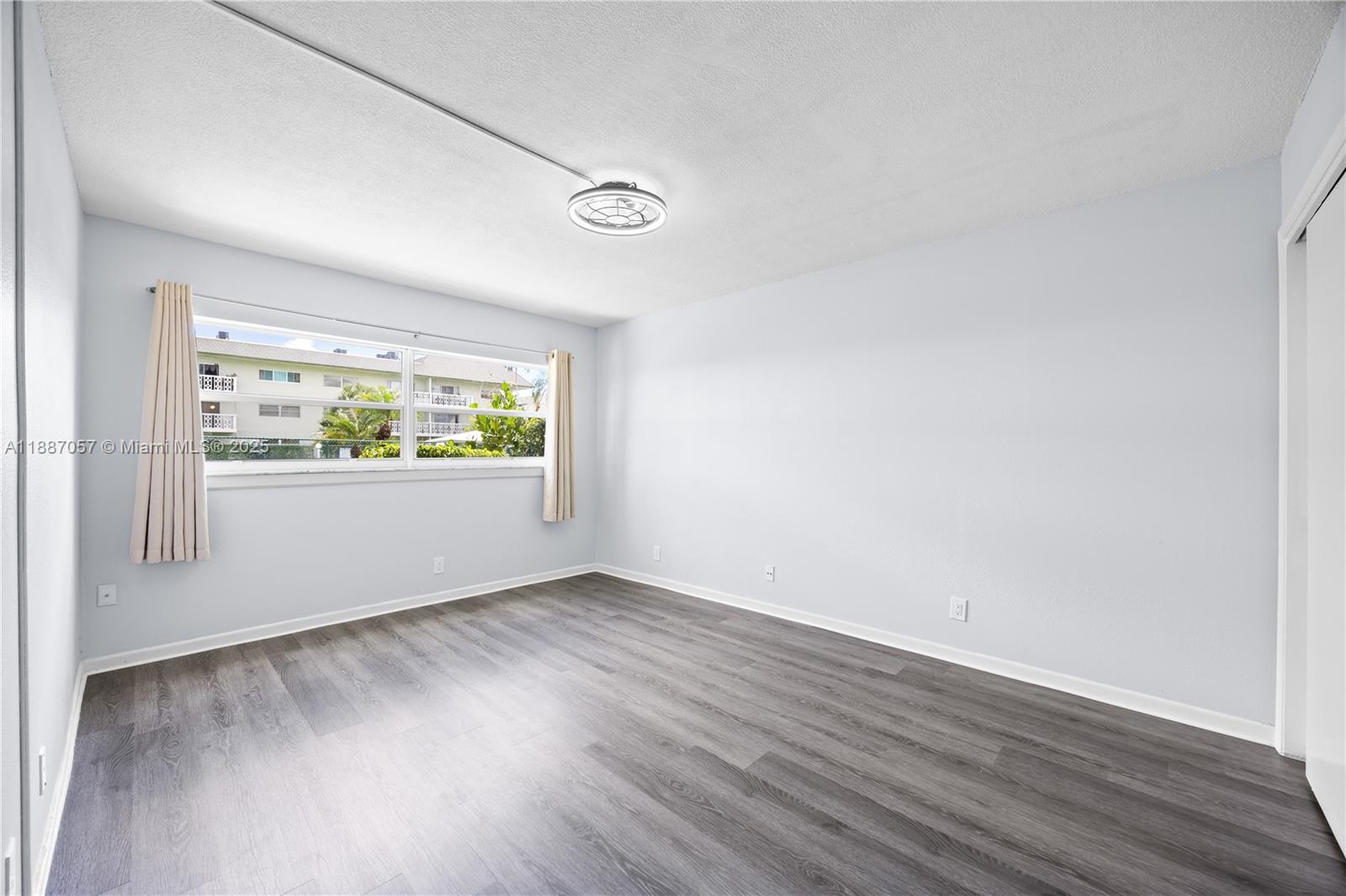 4200 Northwest 3rd Court, Unit 116 Plantation, FL 33317 - Photo 11 of 18 an empty room with wooden floor and windows