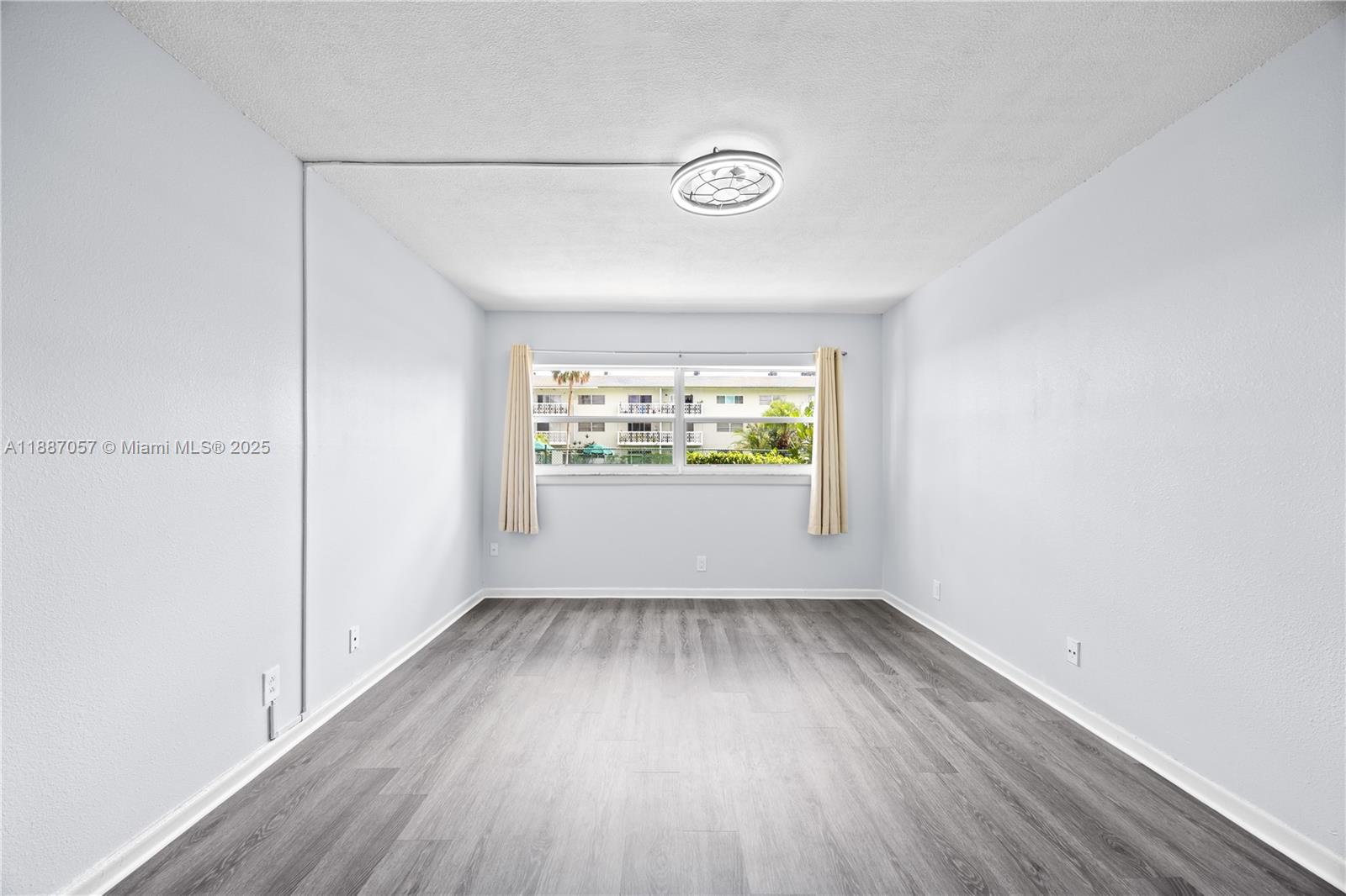 4200 Northwest 3rd Court, Unit 116 Plantation, FL 33317 - Photo 12 of 18 an empty room with wooden floor and windows