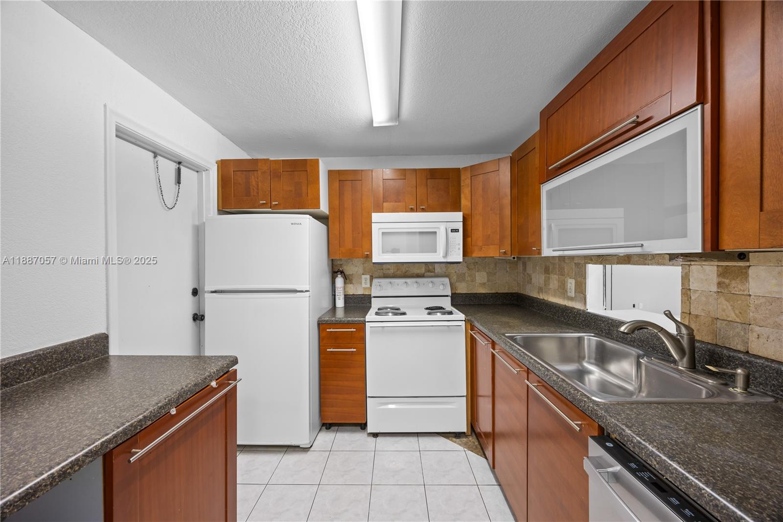 4200 Northwest 3rd Court, Unit 116 Plantation, FL 33317 - Photo 7 of 18 a kitchen with a sink a stove and a refrigerator