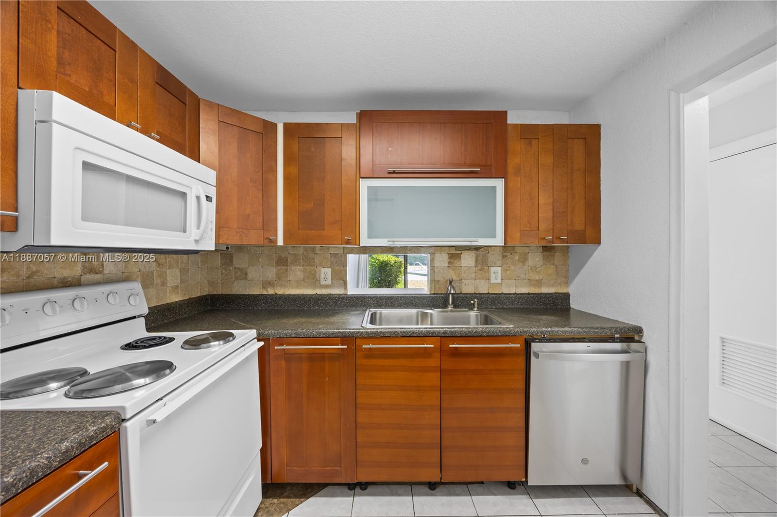 4200 Northwest 3rd Court, Unit 116 Plantation, FL 33317 - Photo 8 of 18 a kitchen with a sink stove and microwave