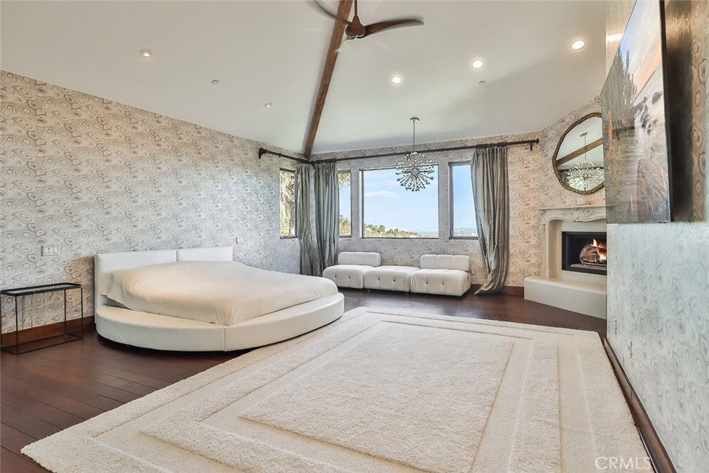 10 Sage Lane Bell Canyon, CA 91307 - Photo 32 of 65 a spacious bedroom with a bed a couch and a fireplace