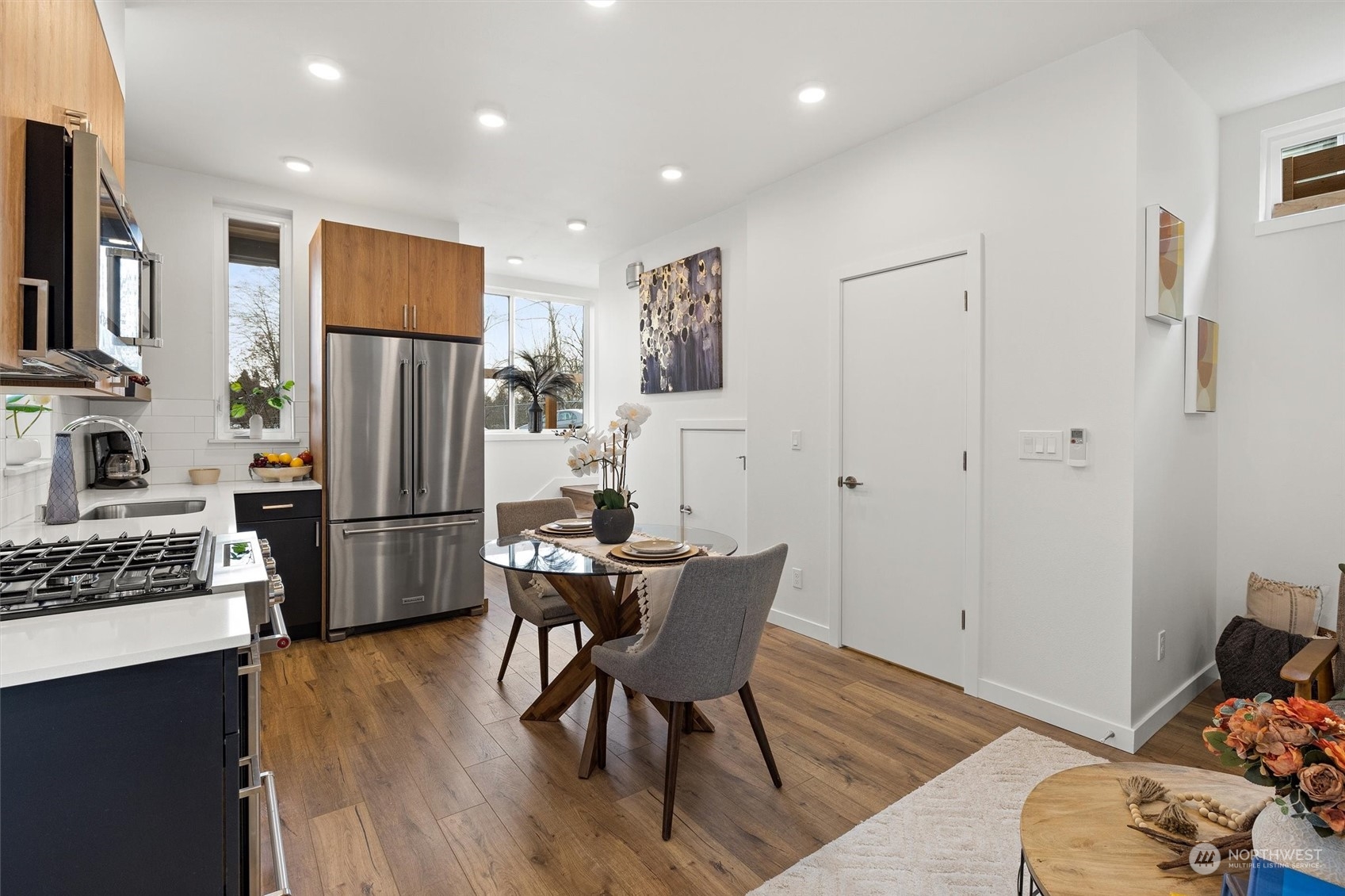 2119 South Walker Street, Unit B Seattle, WA 98144 - Photo 6 of 23 a kitchen with stainless steel appliances a refrigerator a stove a dining table and chairs