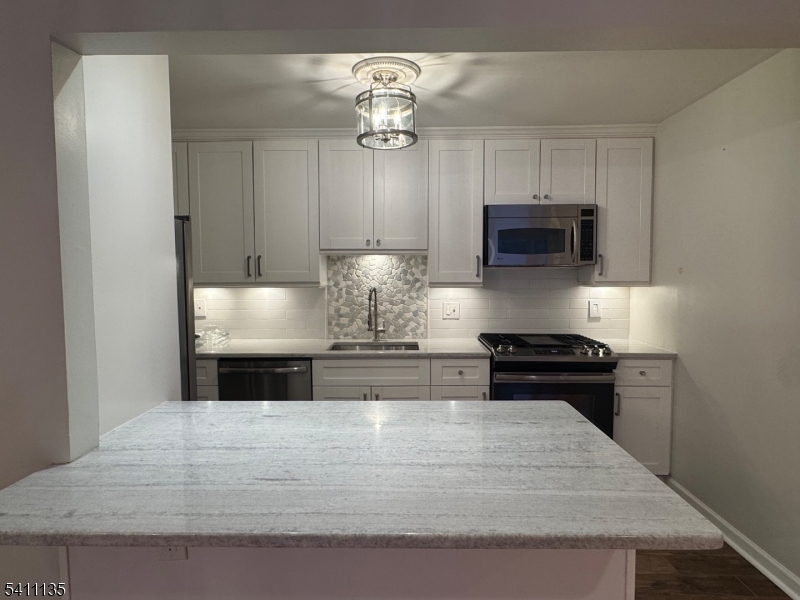50 West Lindsley Road, Unit 42 Cedar Grove, NJ 07009 - Photo 1 of 26 a kitchen with stainless steel appliances granite countertop a stove and a white cabinets