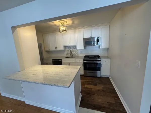 a kitchen with granite countertop a refrigerator and a stove