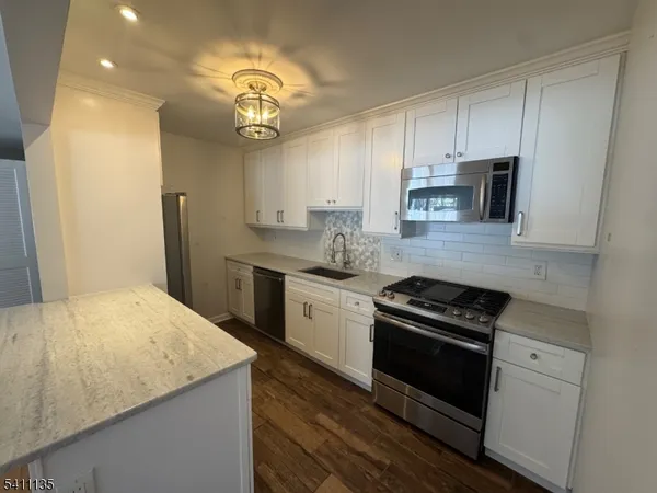 a kitchen with stainless steel appliances granite countertop a stove and a refrigerator