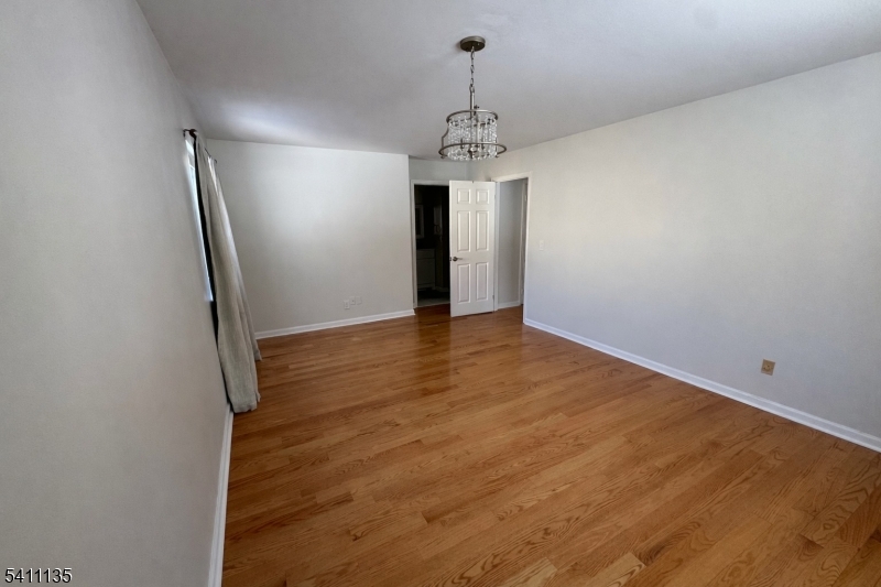50 West Lindsley Road, Unit 42 Cedar Grove, NJ 07009 - Photo 9 of 26 an empty room with wooden floor and hallway