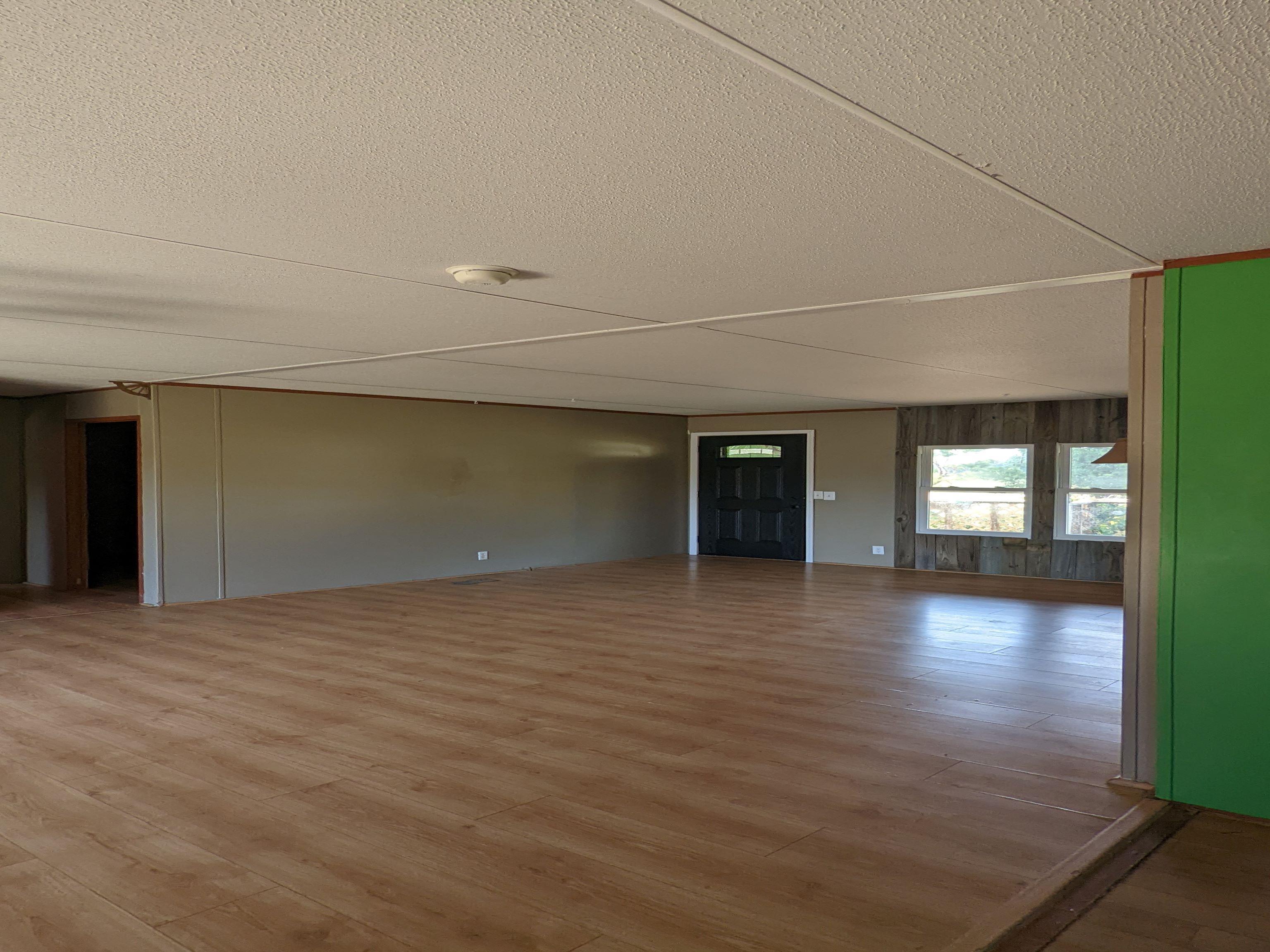 793 Robertson Road Mason, TN 38049 - Photo 4 of 23 a view of an empty room with window and wooden floor