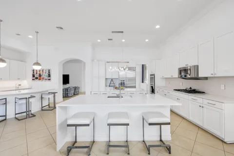 a large kitchen with kitchen island a table and chairs in it
