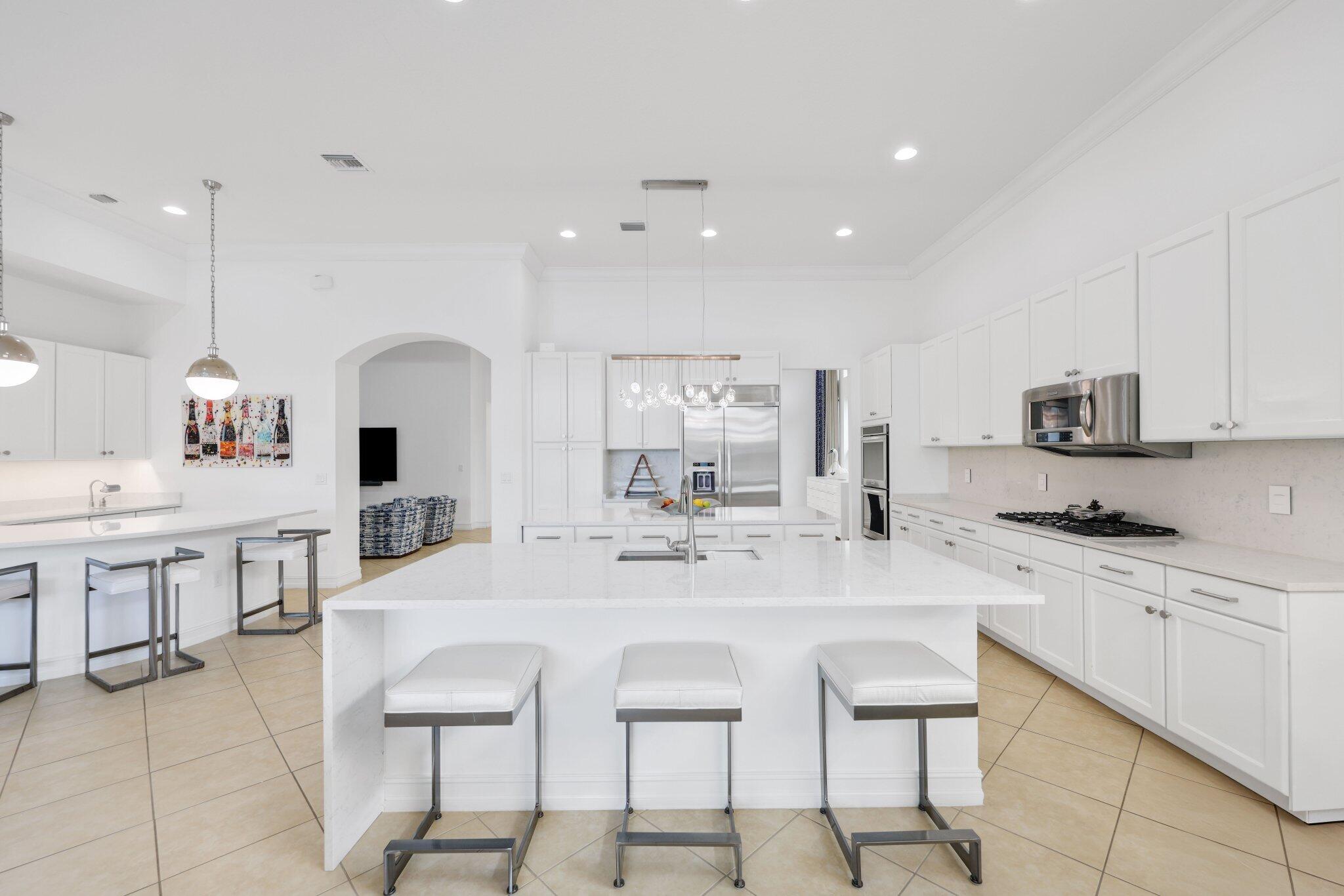 8539 Lewis River Road Delray Beach, FL 33446 - Photo 15 of 49 a large kitchen with kitchen island a table and chairs in it