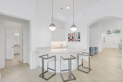 a kitchen with a dining table chairs and a chandelier