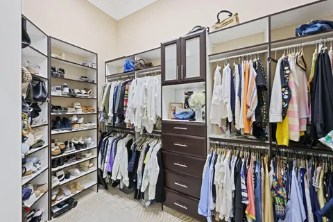a view of walk in closet with clothes