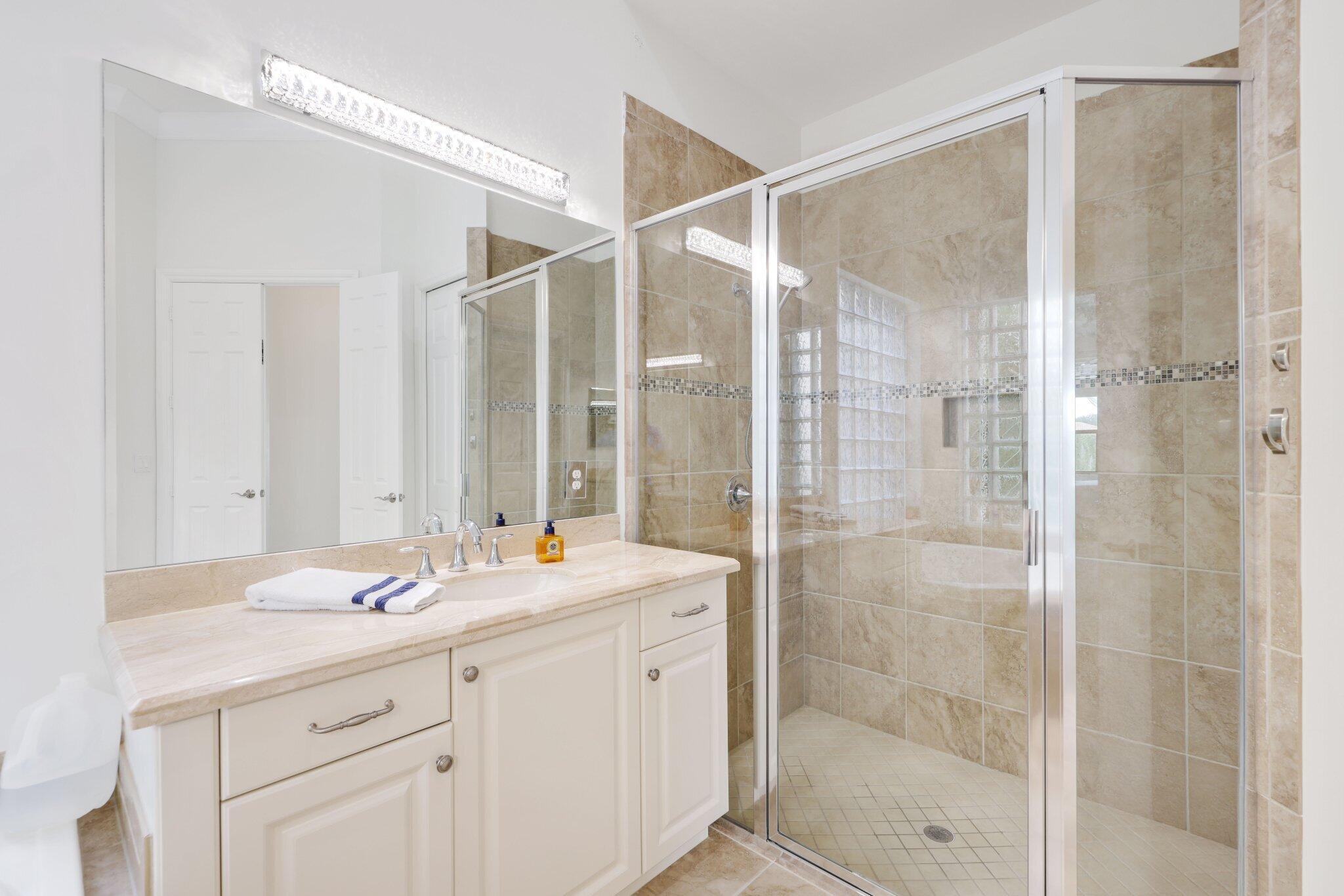 8539 Lewis River Road Delray Beach, FL 33446 - Photo 28 of 49 a bathroom with a shower sink and mirror